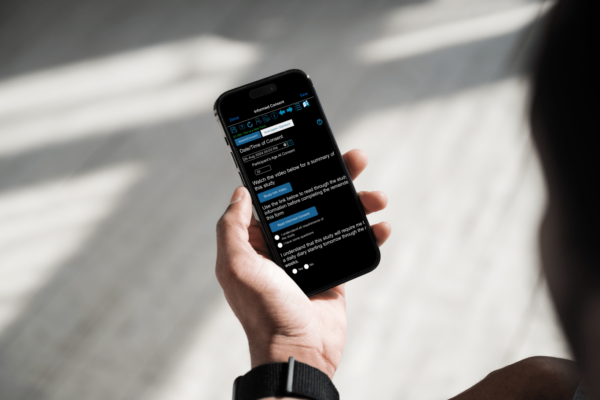 Person holding smartphone with informed consent form displayed on screen in the TrialKit mobile app